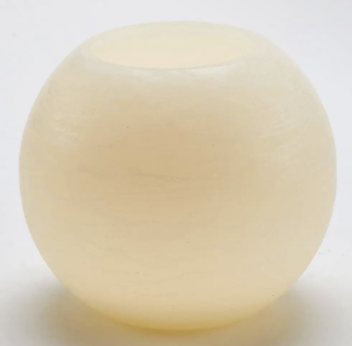 Off-white illuminating sphere candle with a softly textured finish