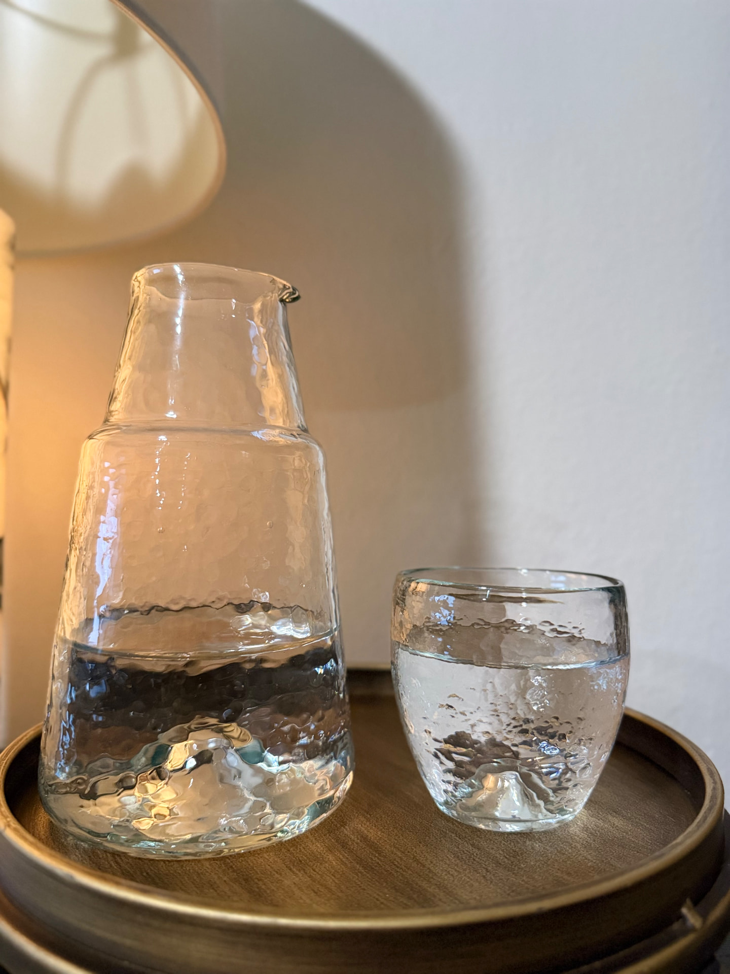 Recycled-glass carafe and its included drinking glass shown side by side