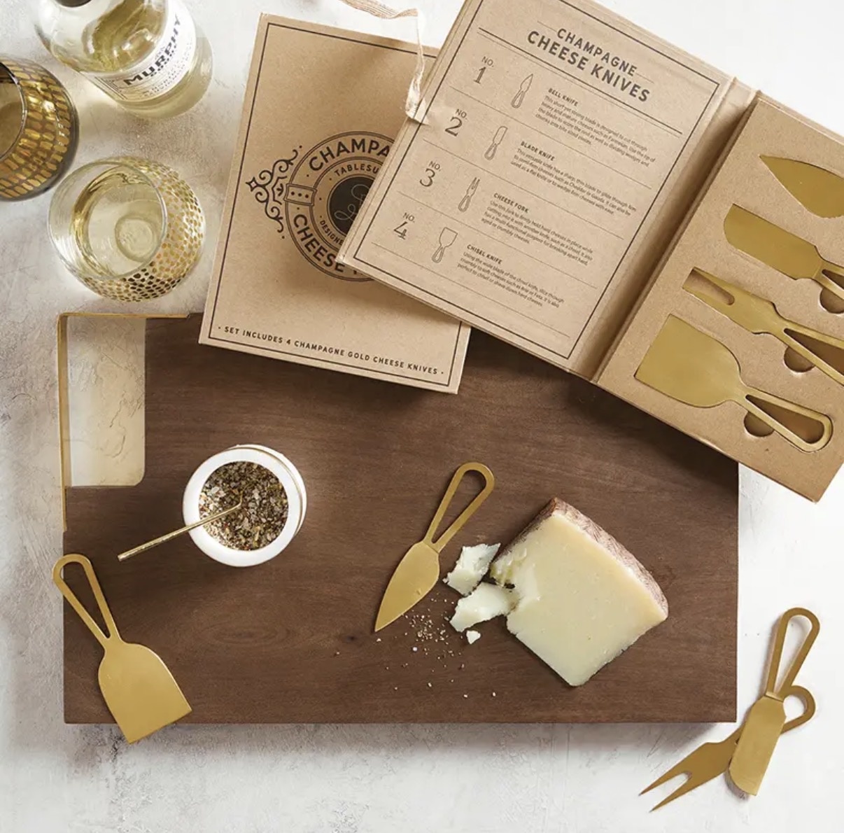 Wine and cheese with champagne gold cheese knives styled for hosting