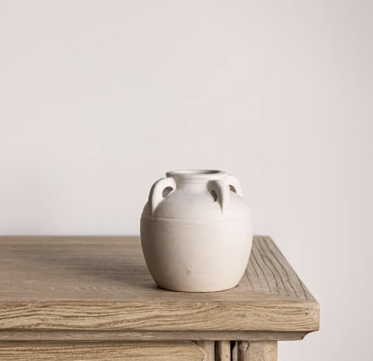 White handled vase on a wooden table