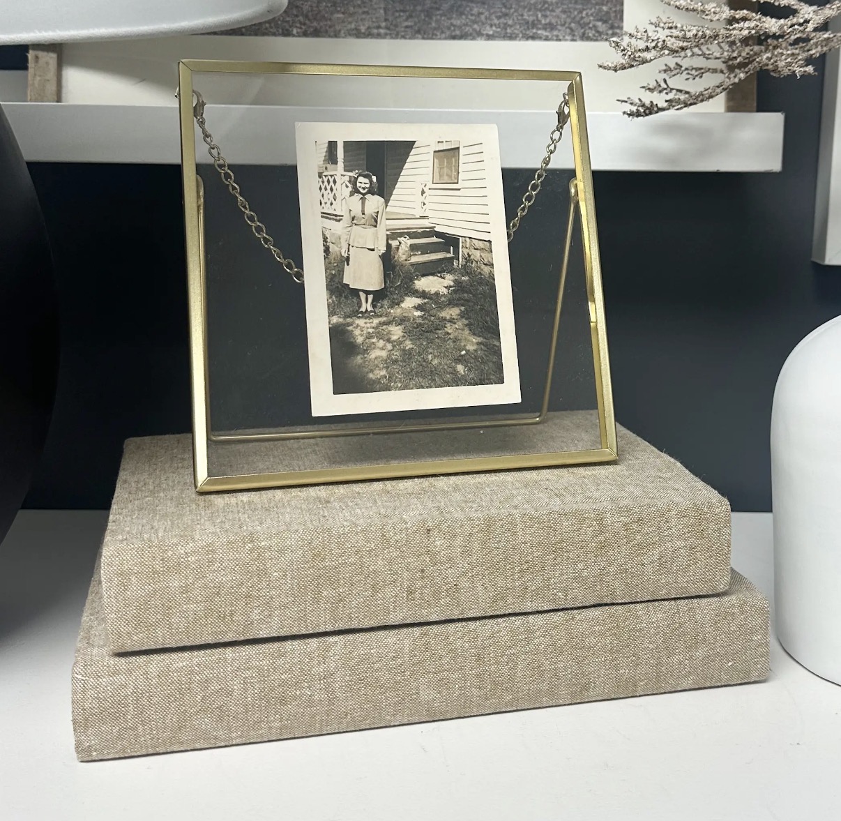 Two linen-bound books with a gold photo frame on top